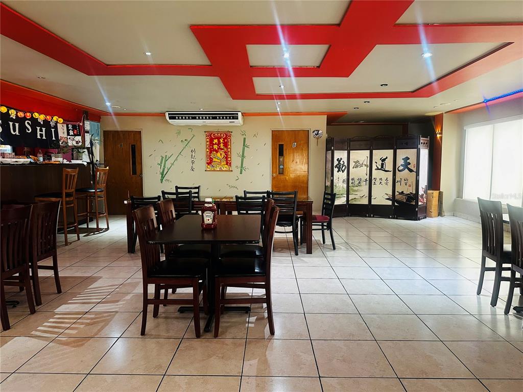 A restaurant dining area features tiled floors, wooden tables, chairs, and decorative Asian-style wall art — 1260 CORNER CORCHADO ST., SANTURCE WARD, SAN JUAN, PR