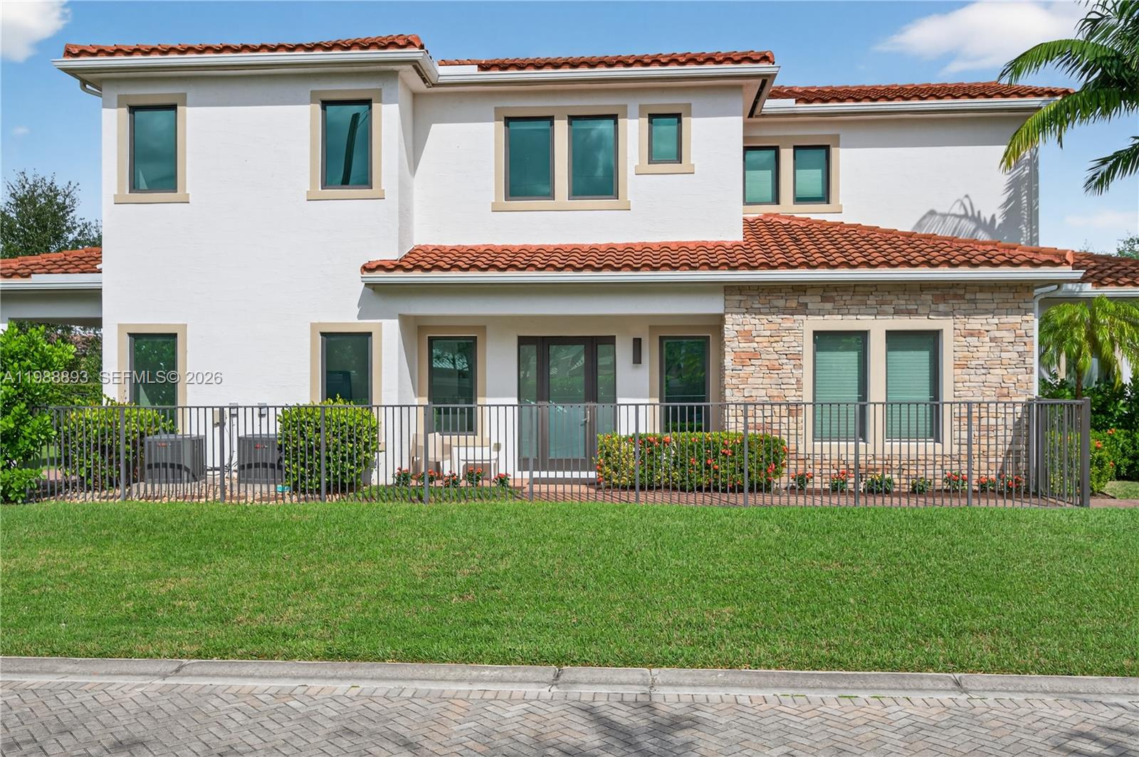 The exterior of a two-story house features white stucco walls, a tile roof, and stone accents — 5999 E Brookfield Cir E, Hollywood FL 33312, HOLLYWOOD, FL