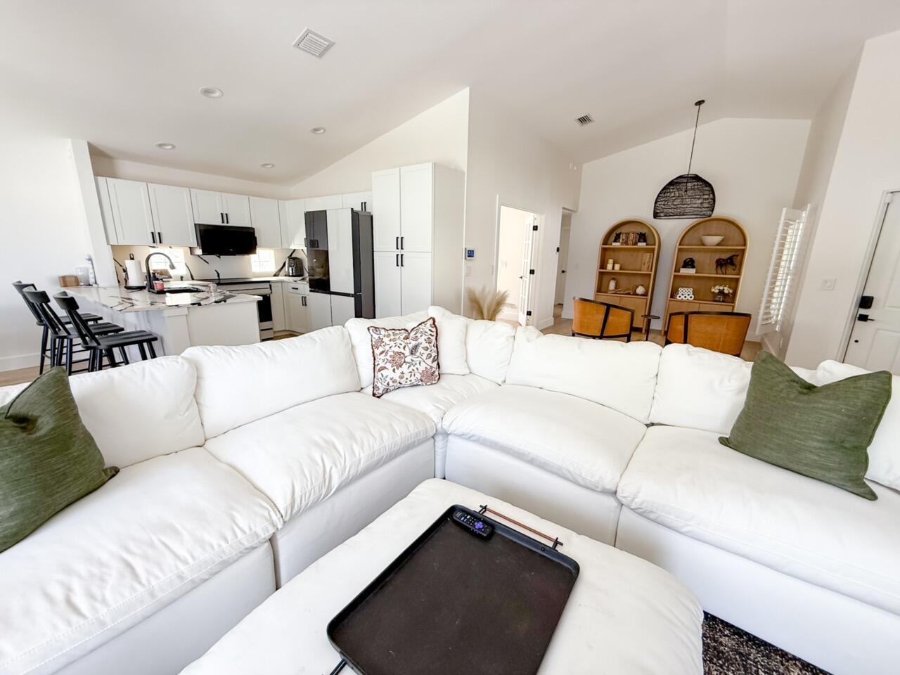 A white sectional sofa faces a modern kitchen with white cabinets and a marble island — 7895 Manor Forest Boulevard, Boynton Beach FL 33436, BOYNTON BEACH, FL