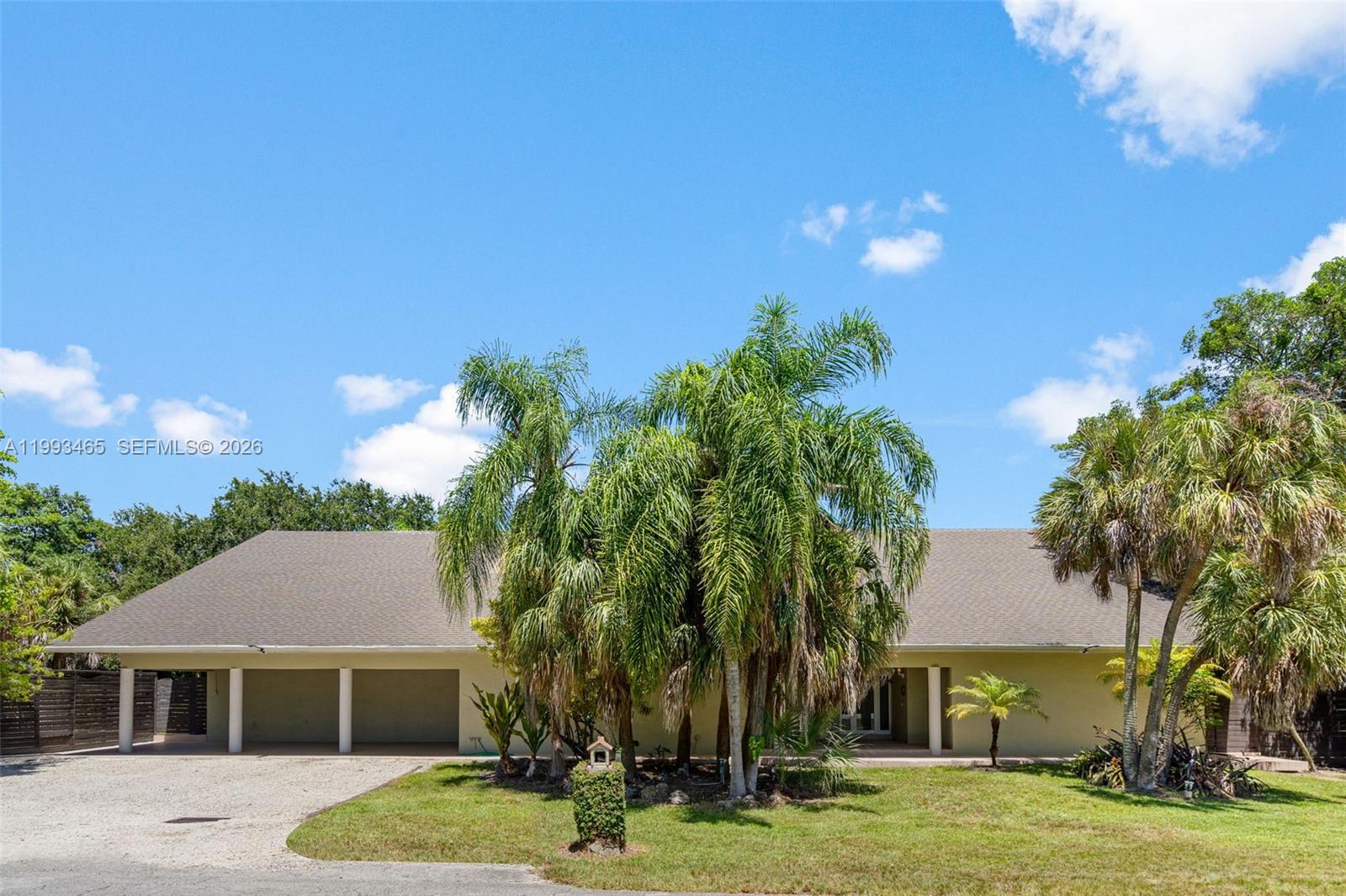 A single-story house features a two-car garage, palm trees, and a gravel driveway — 7997 SW 76th Avenue, Miami FL 33143, MIAMI, FL