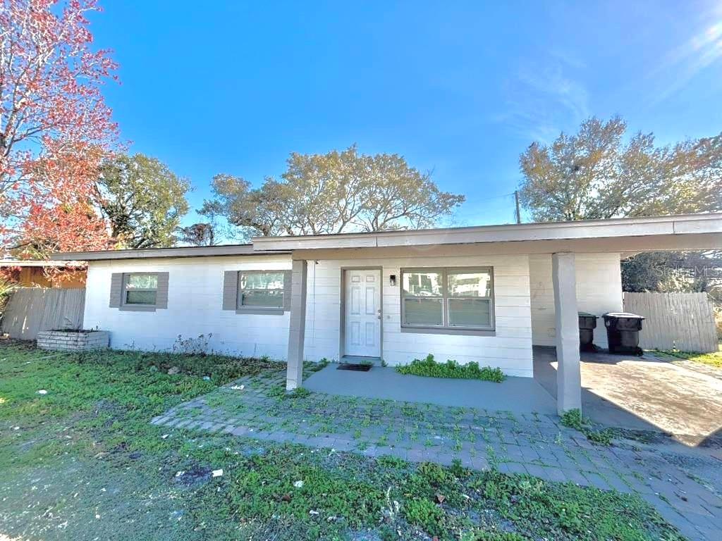 A single-story house with a white exterior, a front porch, and an attached carport — 4314 SILVER STAR ROAD, ORLANDO, FL