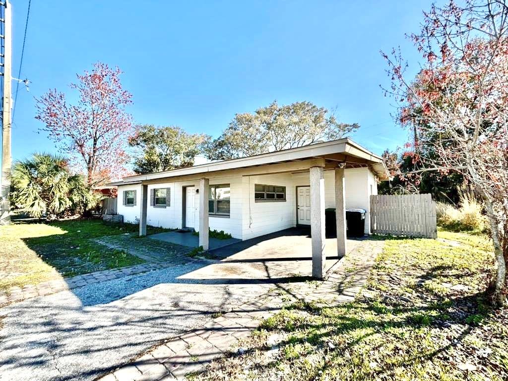 A single-story white house with a carport and a wooden fence on a sunny day — 4314 SILVER STAR ROAD, ORLANDO, FL