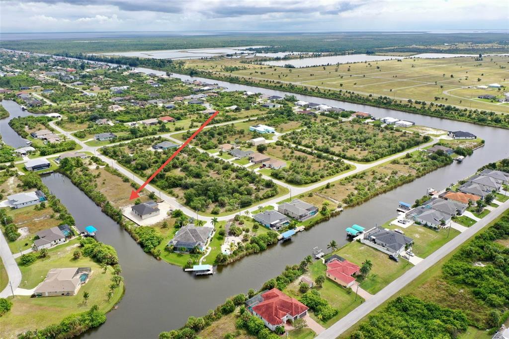 An aerial view shows a single-family home situated on a canal-front lot — 10868 MCALESTER CIRCLE, PORT CHARLOTTE, FL