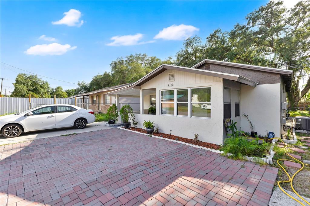 A single-story house with a paved driveway, white exterior, and a covered front porch — 1101 28TH STREET NW, WINTER HAVEN, FL