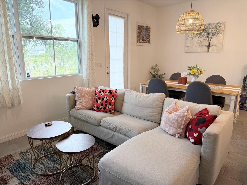 A living room with a sectional sofa, two round coffee tables, and a dining area — 864 LONGBOAT DRIVE, DAVENPORT, FL