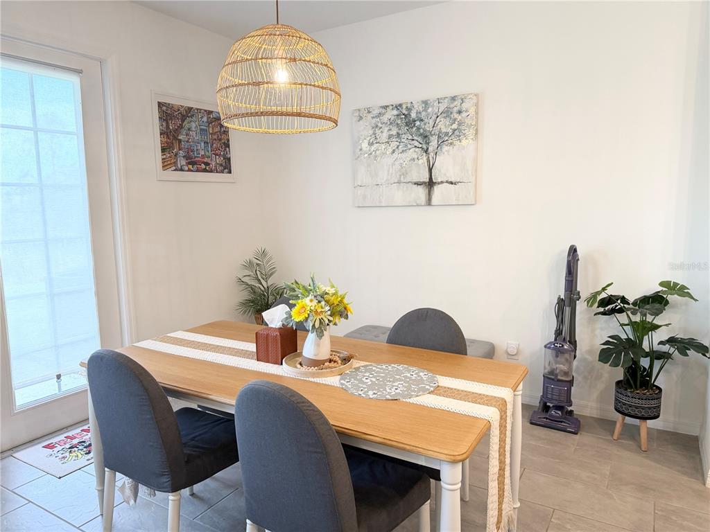 A dining area features a wooden table, grey chairs, a rattan pendant light, and artwork — 864 LONGBOAT DRIVE, DAVENPORT, FL