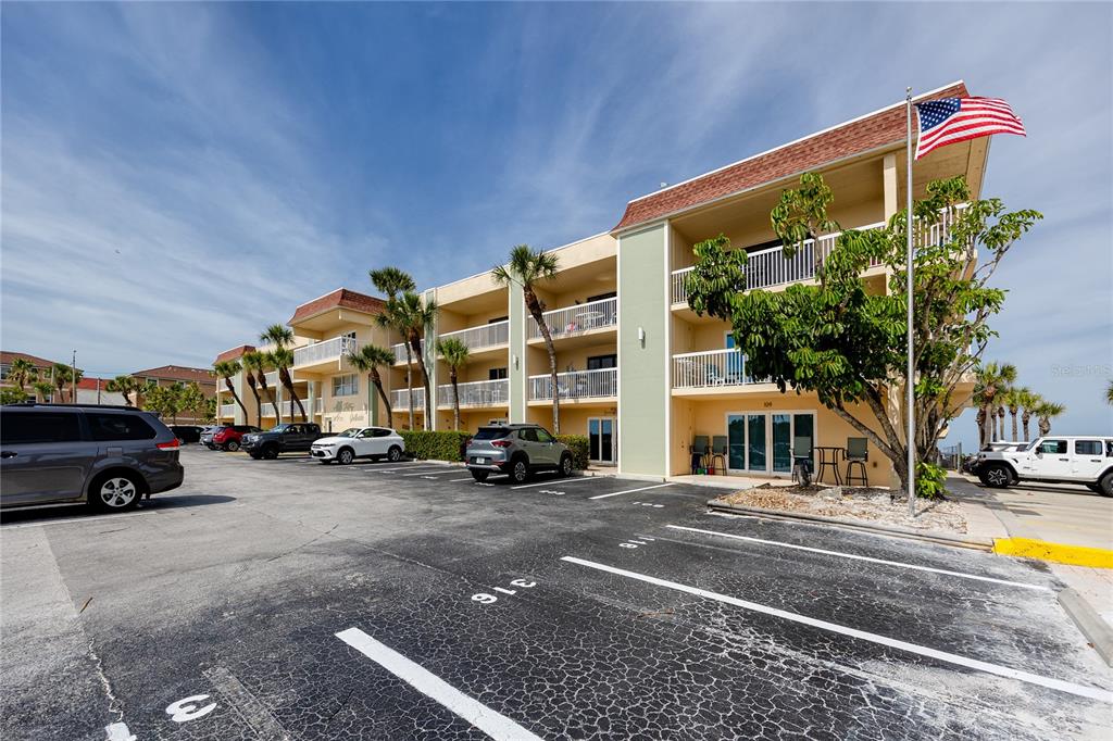A multi-story apartment building with balconies and a parking lot in the foreground — 50 GULF BOULEVARD UNIT 108, INDIAN ROCKS BEACH, FL