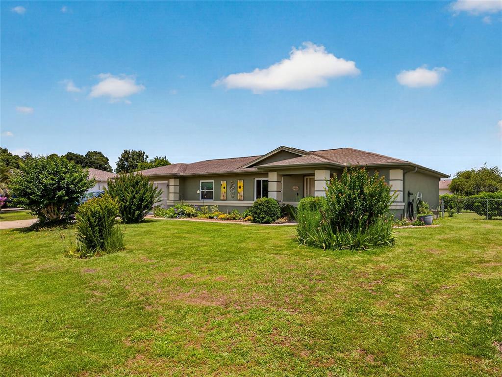 A single-story house with a green exterior, a brown roof, and a large front lawn — 6341 SW 103RD LANE, OCALA, FL