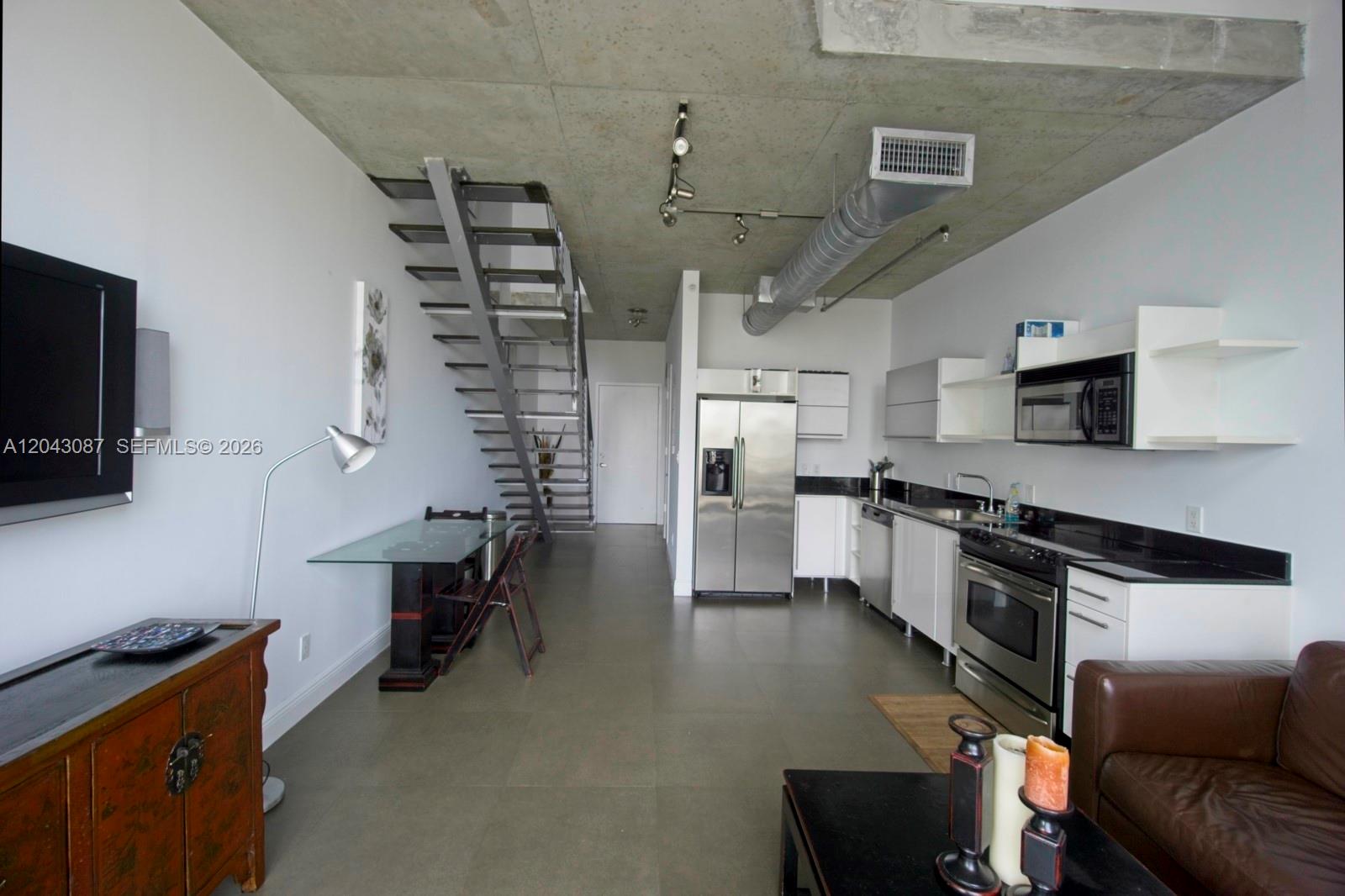 A modern staircase with dark wooden treads and a metal railing sits in a hallway — 690 SW 1 Ct # 2703, Miami FL 33130, MIAMI, FL