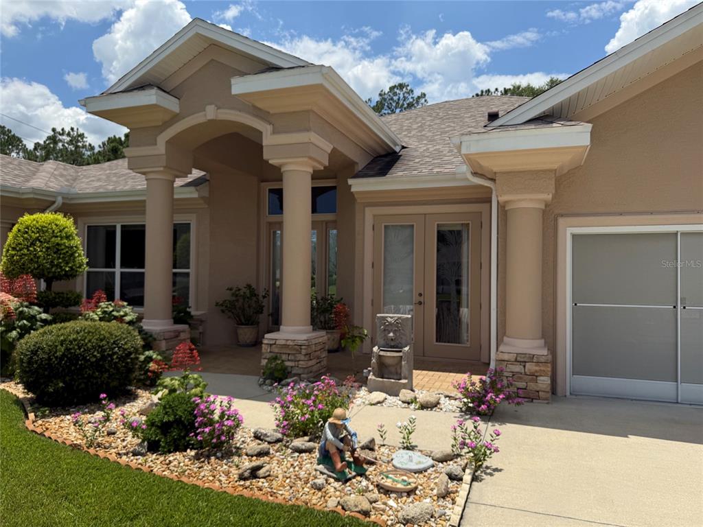 The exterior of a tan house features a covered entryway with columns and double doors — 96 ESPERANTO DRIVE, PALM COAST, FL