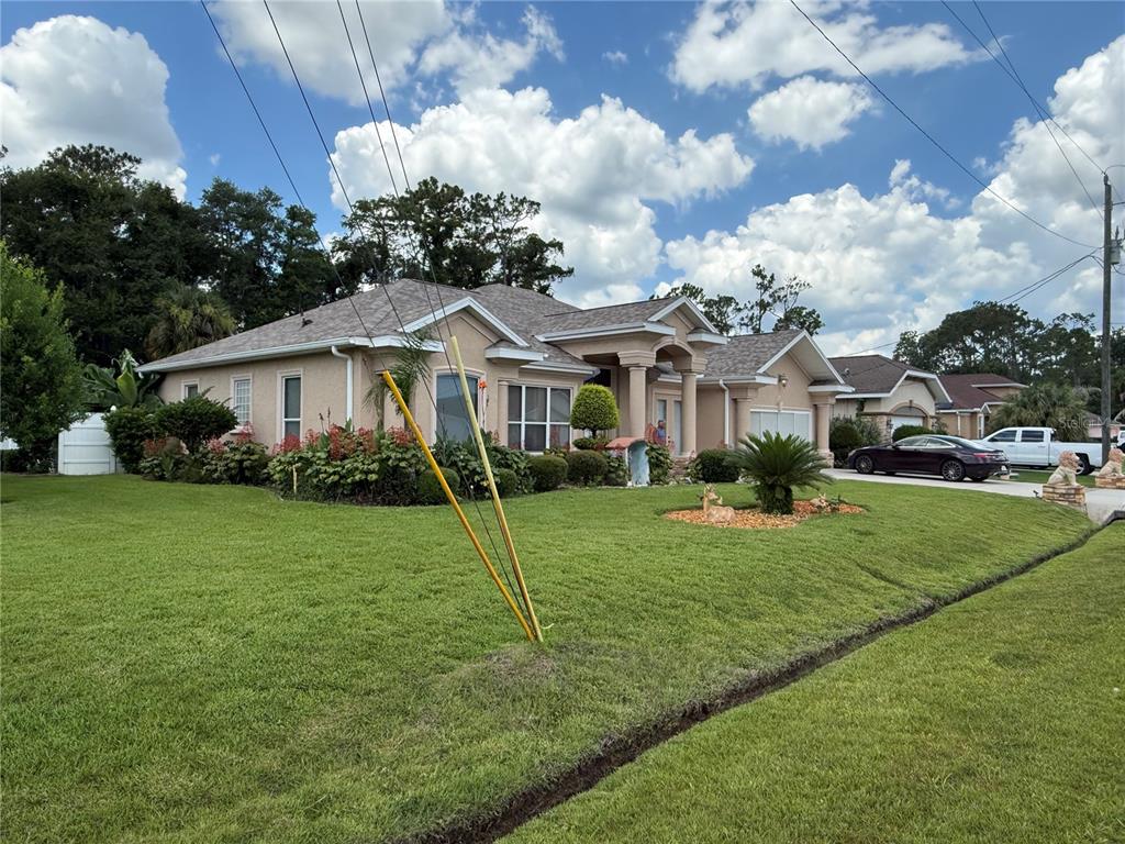 A single-story tan house with a gabled roof and a manicured lawn — 96 ESPERANTO DRIVE, PALM COAST, FL