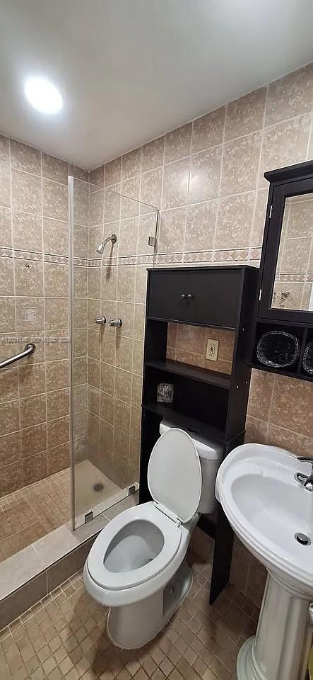 A bathroom features a glass-enclosed shower, a toilet with a storage unit, and a pedestal sink — 7860 SW 17th St # A, Miami FL 33155, MIAMI, FL
