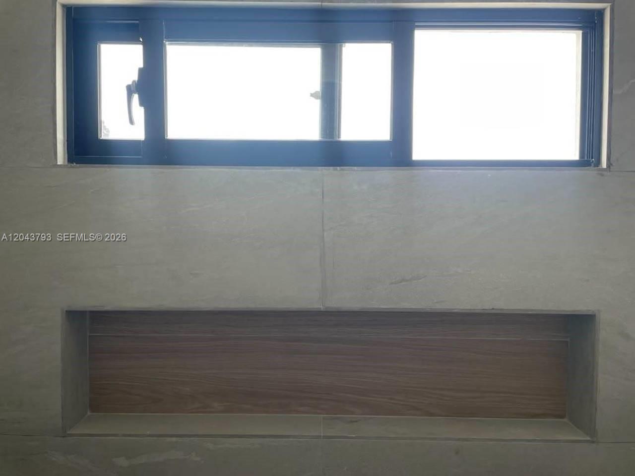 A rectangular wall niche with a wood-look finish is set below a horizontal window — 0 residencial brisas, FL