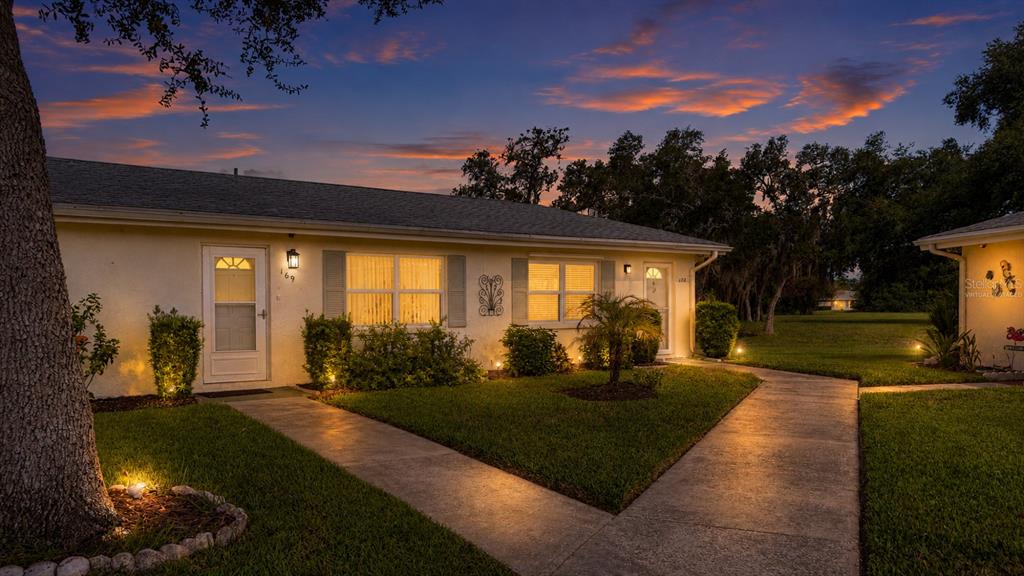 A single-story duplex exterior with lit walkways and windows at twilight — 301 ANDOVER PLACE S UNIT 170, SUN CITY CENTER, FL