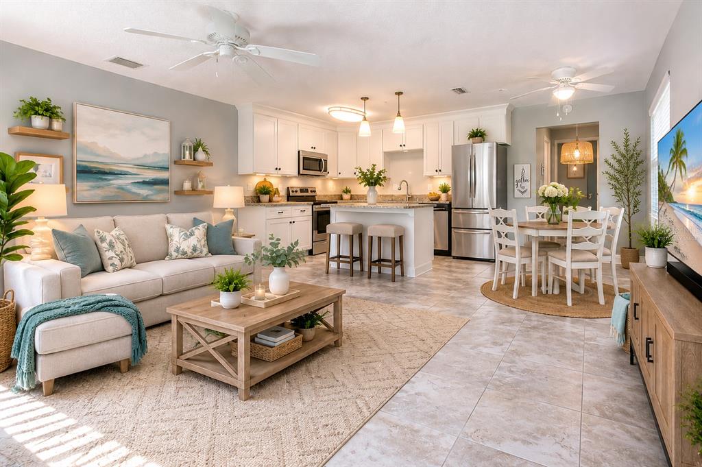 An open-concept living room and kitchen featuring light-colored cabinetry, stainless steel appliances, and tile flooring — 301 ANDOVER PLACE S UNIT 170, SUN CITY CENTER, FL