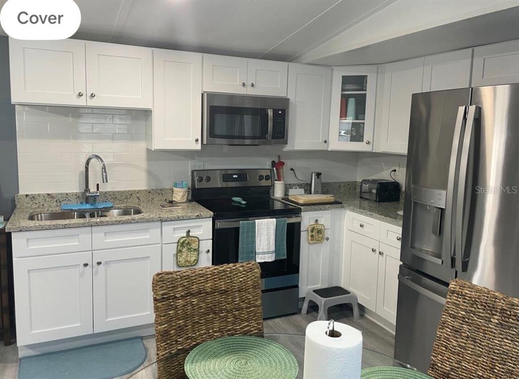 A kitchen with white cabinets, stainless steel appliances, and granite countertops — 5830 PORTSMOUTH DRIVE, TAMPA, FL