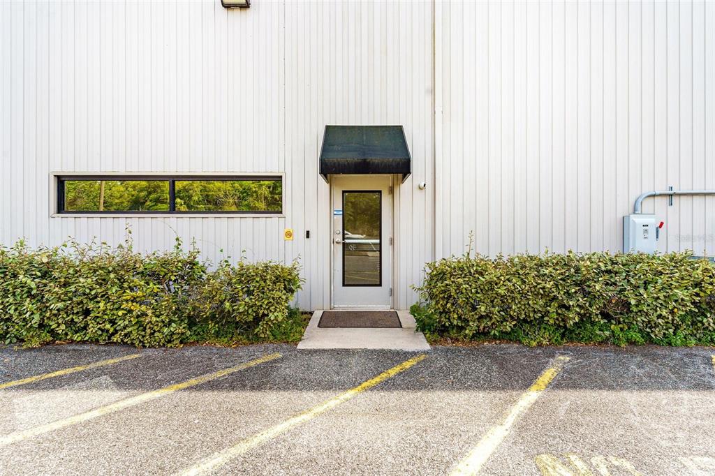 An exterior view of a commercial building entrance with a metal door and awning — 1904 THOMAS AVENUE UNIT 102, LEESBURG, FL