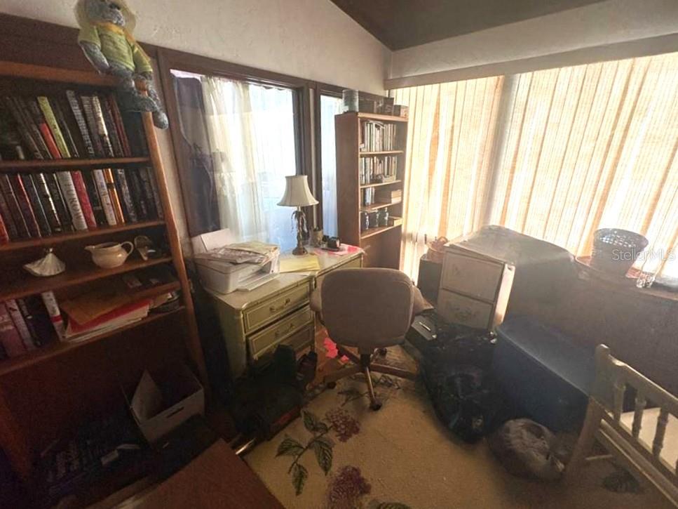 A home office features two wooden bookshelves, a desk with a lamp, and a chair — 122 FAIRWAY DRIVE, HAINES CITY, FL