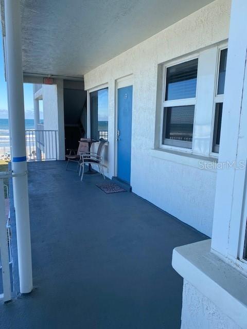 A studio apartment features wood-look flooring, a small kitchenette, a bed, and a dining set — 935 S ATLANTIC AVE UNIT 255, DAYTONA BEACH, FL
