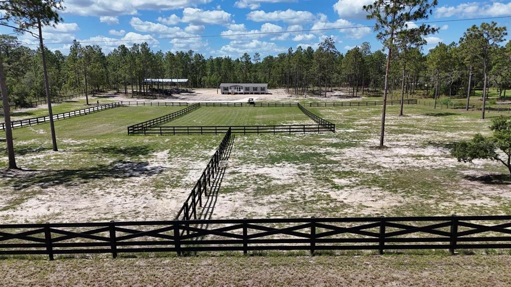 An aerial view shows a fenced pasture with a house and trees in the background — 14270 SE 60 STREET, MORRISTON, FL