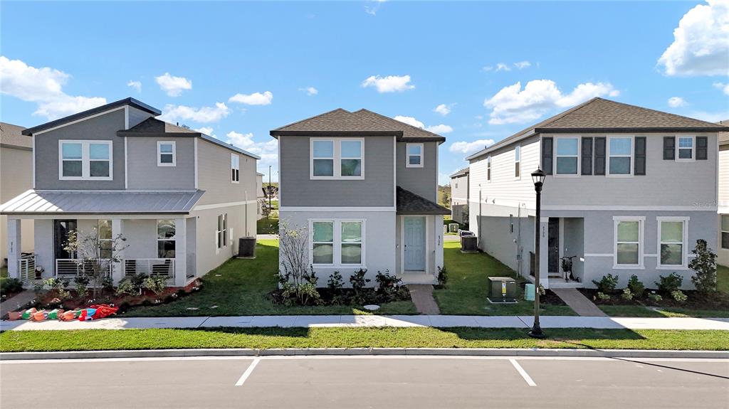 Three modern two-story suburban houses stand side-by-side along a paved street — 4704 HOMESTEAD TRAIL, ST CLOUD, FL