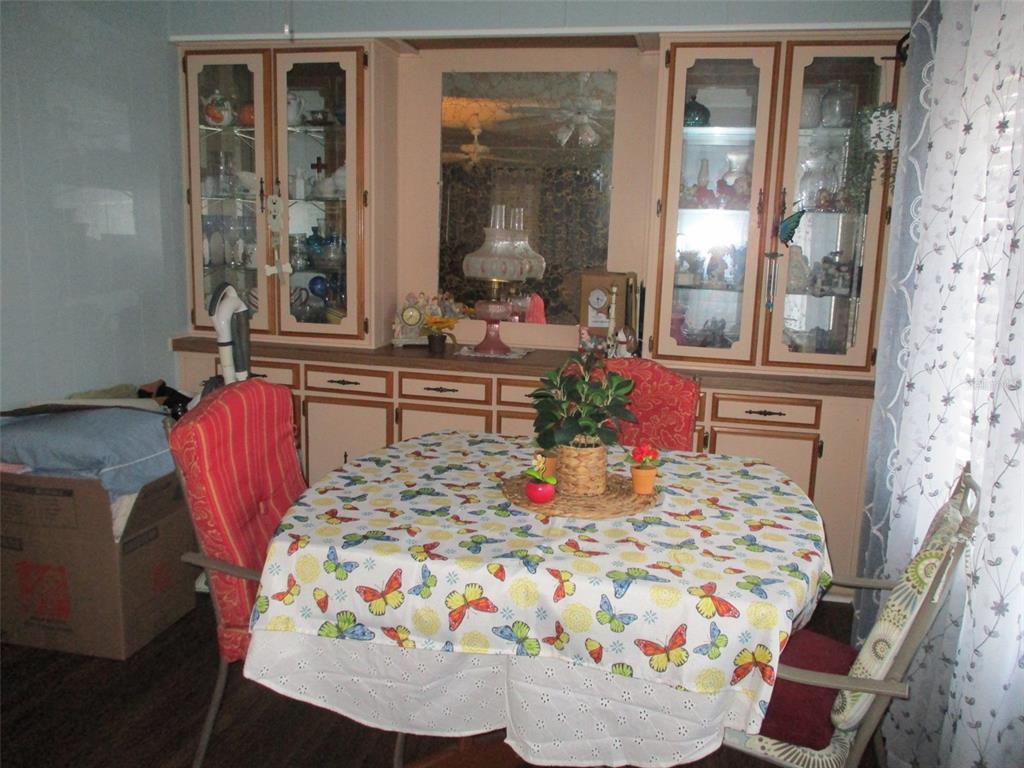 A dining area features a round table with a butterfly tablecloth and built-in cabinetry — 38536 CONE DRIVE, ZEPHYRHILLS, FL