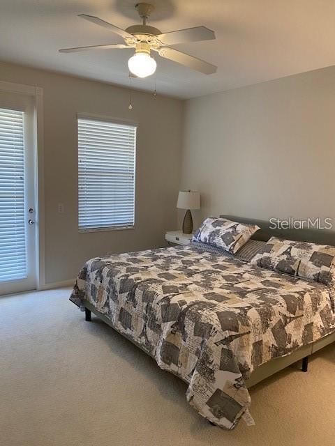 A bedroom features a bed with a patterned quilt, a ceiling fan, and a window — 5361 ELISEO STREET, SARASOTA, FL