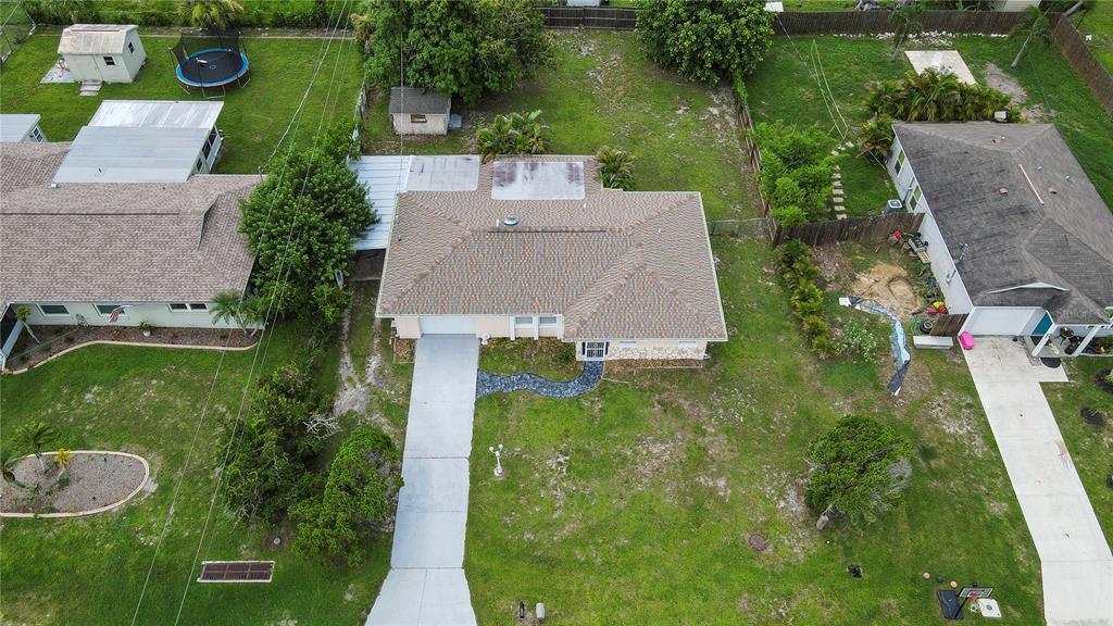An aerial view shows a single-story house with a shingled roof and a concrete driveway — 451 READING STREET NW, PORT CHARLOTTE, FL