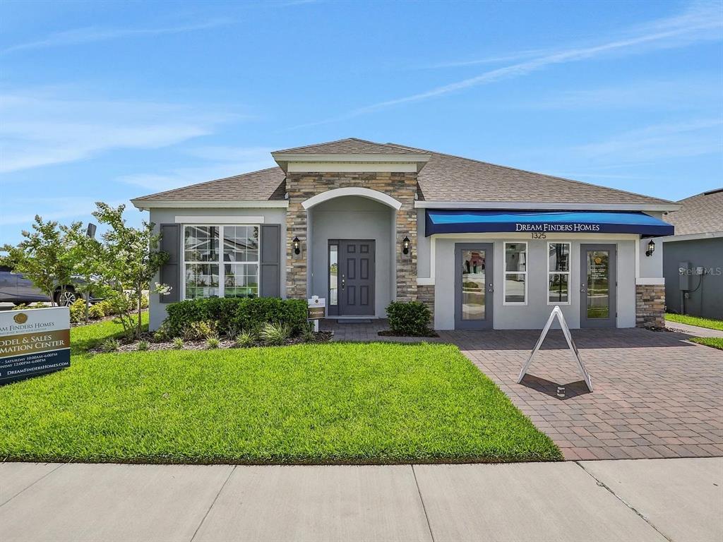 A kitchen with dark wood cabinets and a granite island overlooks an open living area — 123 BOTTLE BRUSH DRIVE, HAINES CITY, FL