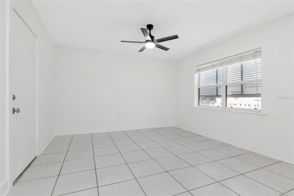 An empty room with white walls, light gray tile flooring, a ceiling fan, and window — 3514 GULF BOULEVARD UNIT 3, ST PETE BEACH, FL