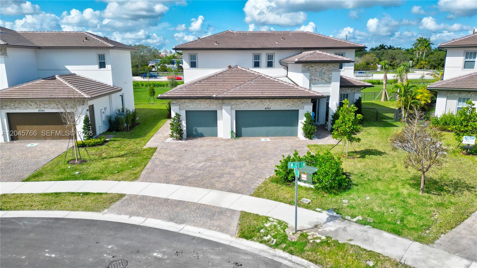An exterior view of a two-story house with a paved driveway and three garage bays — 4367 SW 123 ln, Davie FL 33330, DAVIE, FL