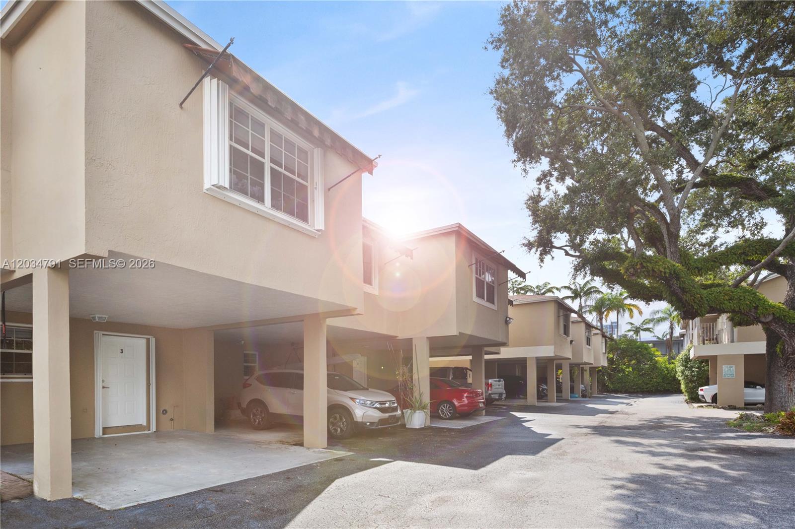 The exterior view shows a row of multi-story townhomes with covered ground-level parking spaces — 3130 Bird Ave # 3, Miami FL 33133, MIAMI, FL