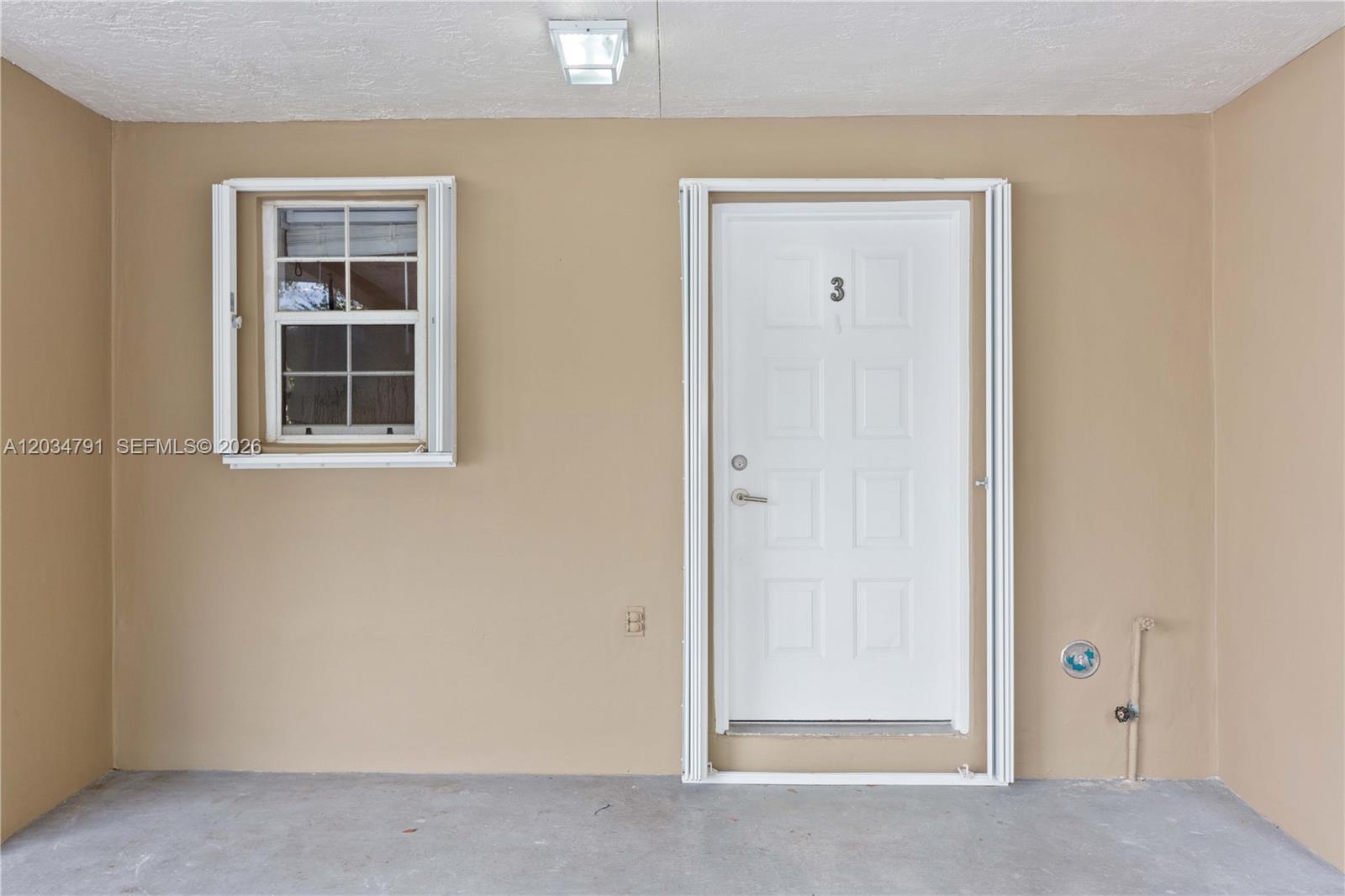 A white door numbered three and a small window are set into a beige wall — 3130 Bird Ave # 3, Miami FL 33133, MIAMI, FL