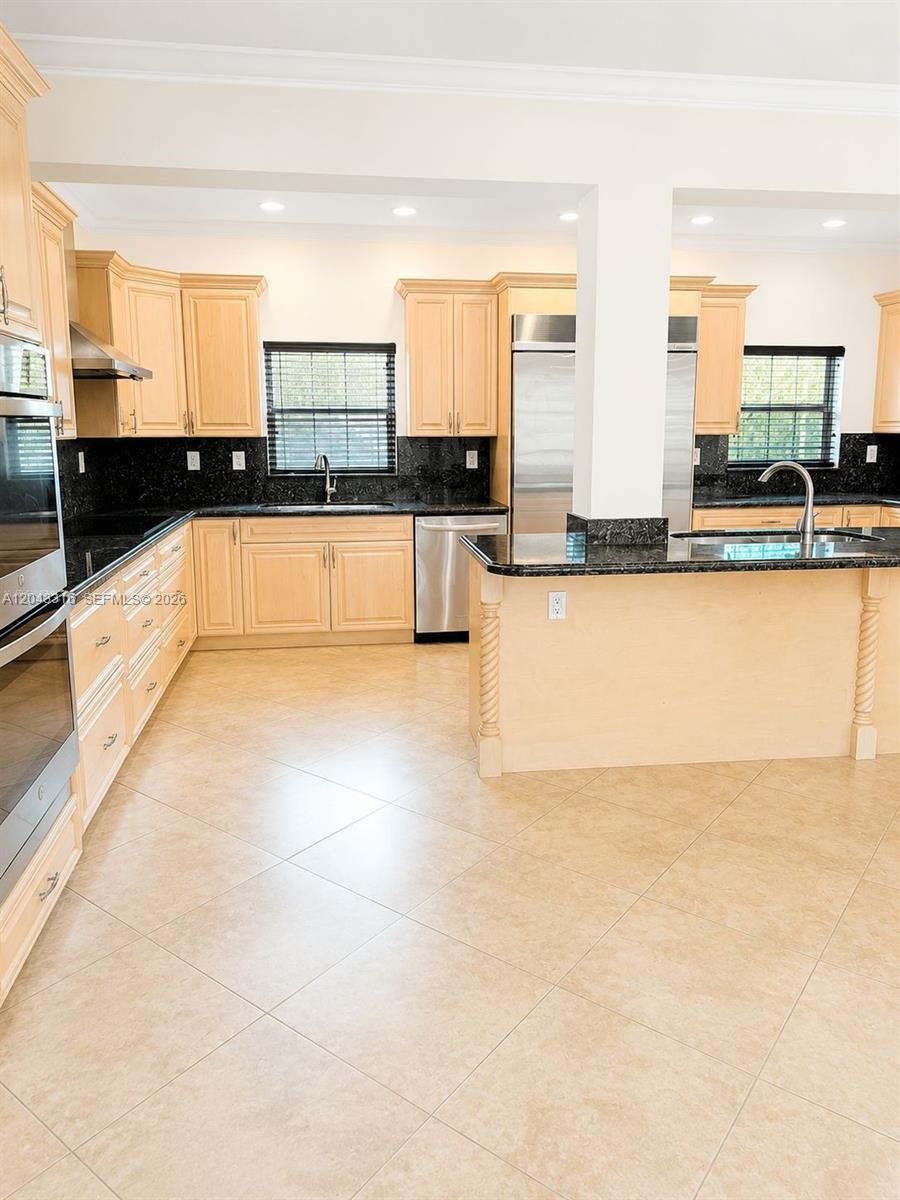 A kitchen features light wood cabinets, black granite countertops, and light-colored tile flooring — 3701 Starboard Ave, Cooper City FL 33026, COOPER CITY, FL