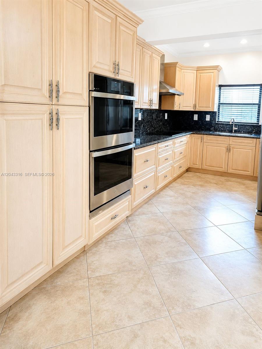 This kitchen features light wood cabinets, stainless steel double ovens, and dark granite countertops — 3701 Starboard Ave, Cooper City FL 33026, COOPER CITY, FL