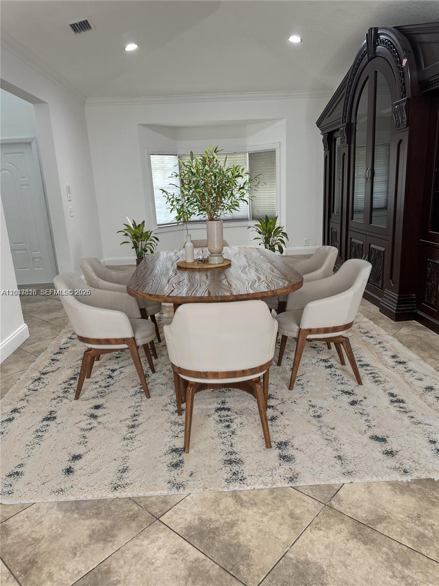 A dining room features a wooden table, six upholstered chairs, and a large dark cabinet — 3701 Starboard Ave, Cooper City FL 33026, COOPER CITY, FL