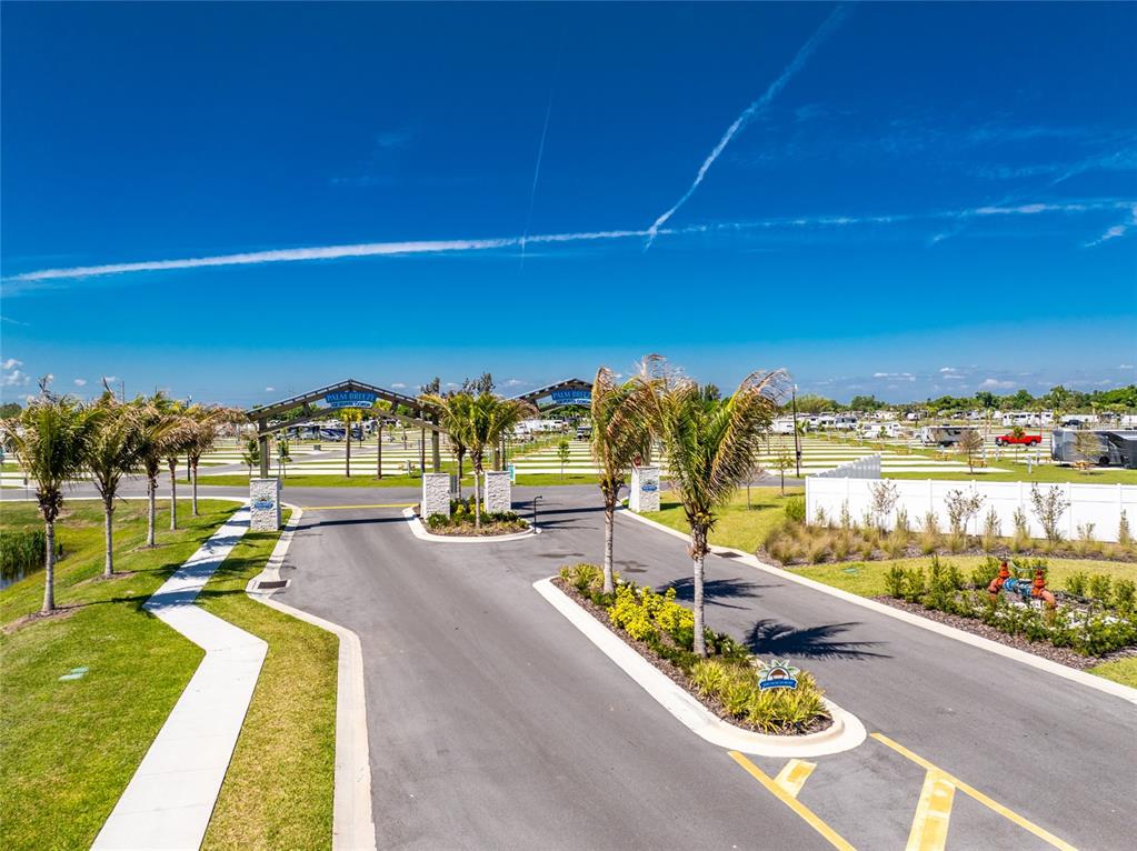 An aerial view shows the gated entrance to an RV resort with palm trees — 443 HORIZON ROAD, PUNTA GORDA, FL