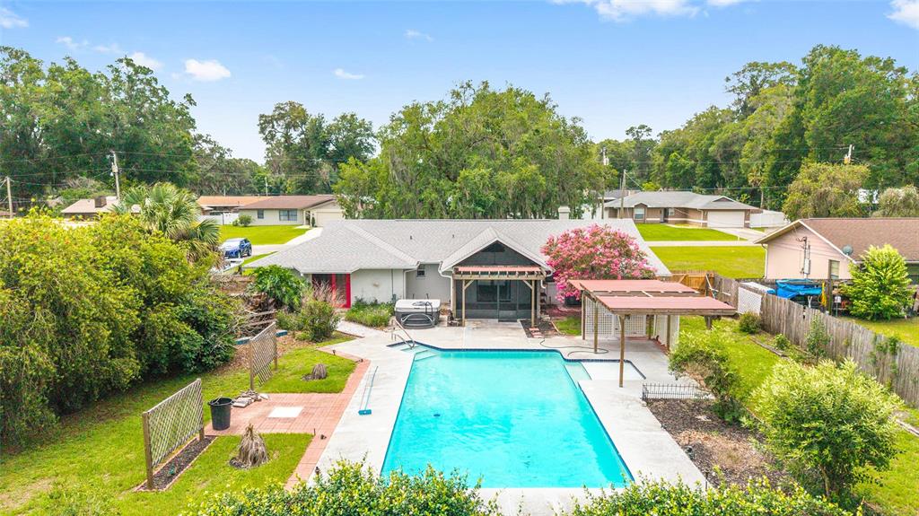 An aerial view shows a house with a swimming pool and a covered patio area — 2079 NE 43RD STREET, OCALA, FL