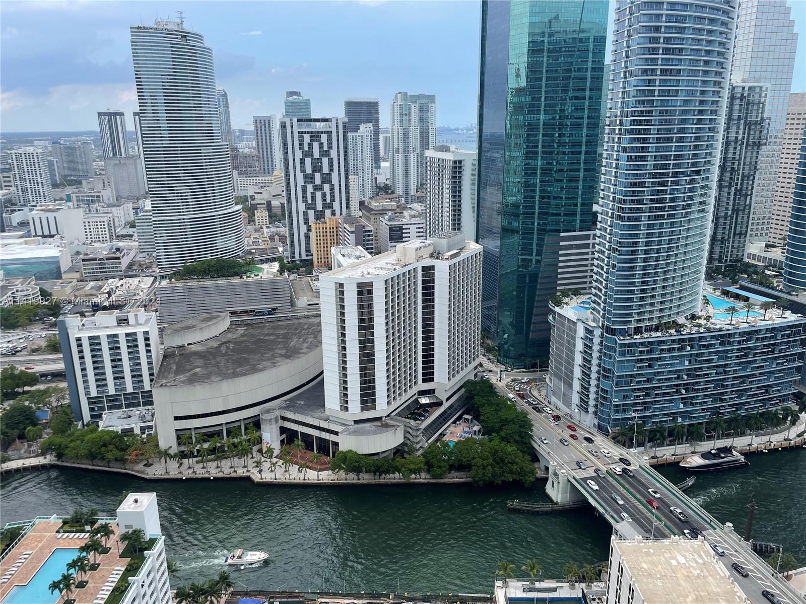 An elevated view of a Miami riverfront cityscape featuring high-rise buildings and a bridge — 55 SE 6th St, Miami FL 33131, MIAMI, FL