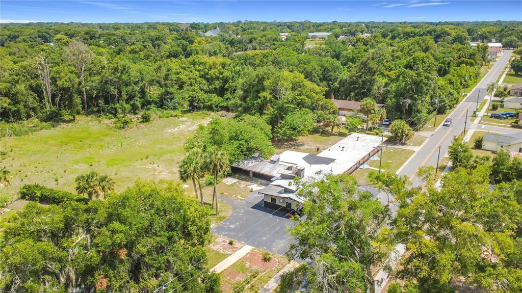 An aerial view shows a low-rise commercial building with a flat roof next to a road — 503 PALMETTO STREET, EUSTIS, FL