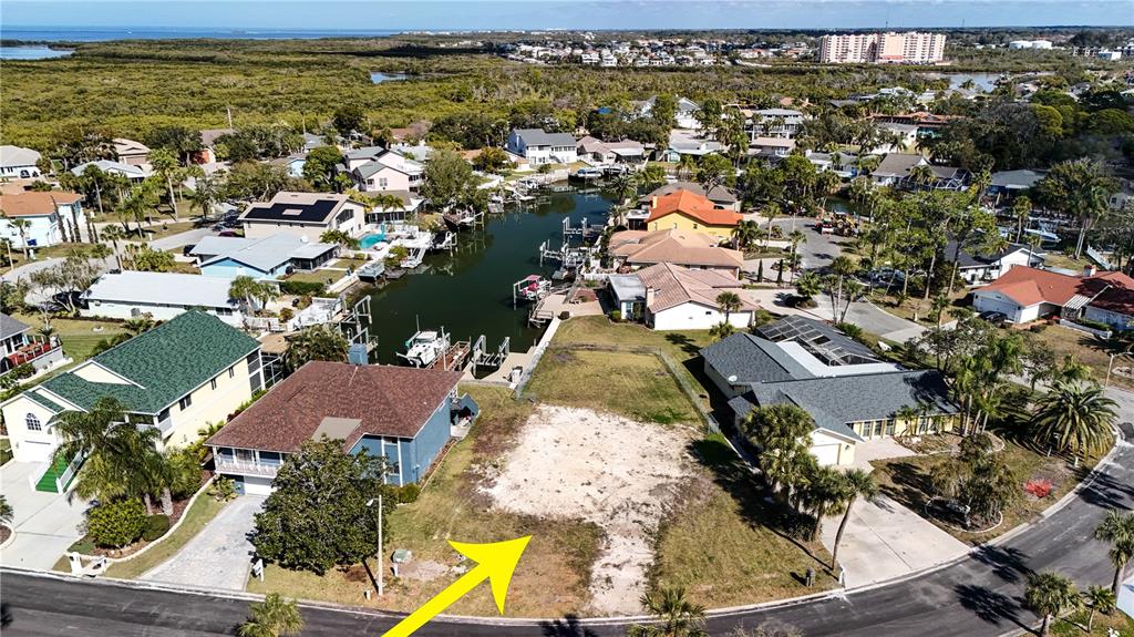 An aerial view shows a vacant waterfront lot situated between two residential houses — 4157 PERRY PLACE, NEW PORT RICHEY, FL