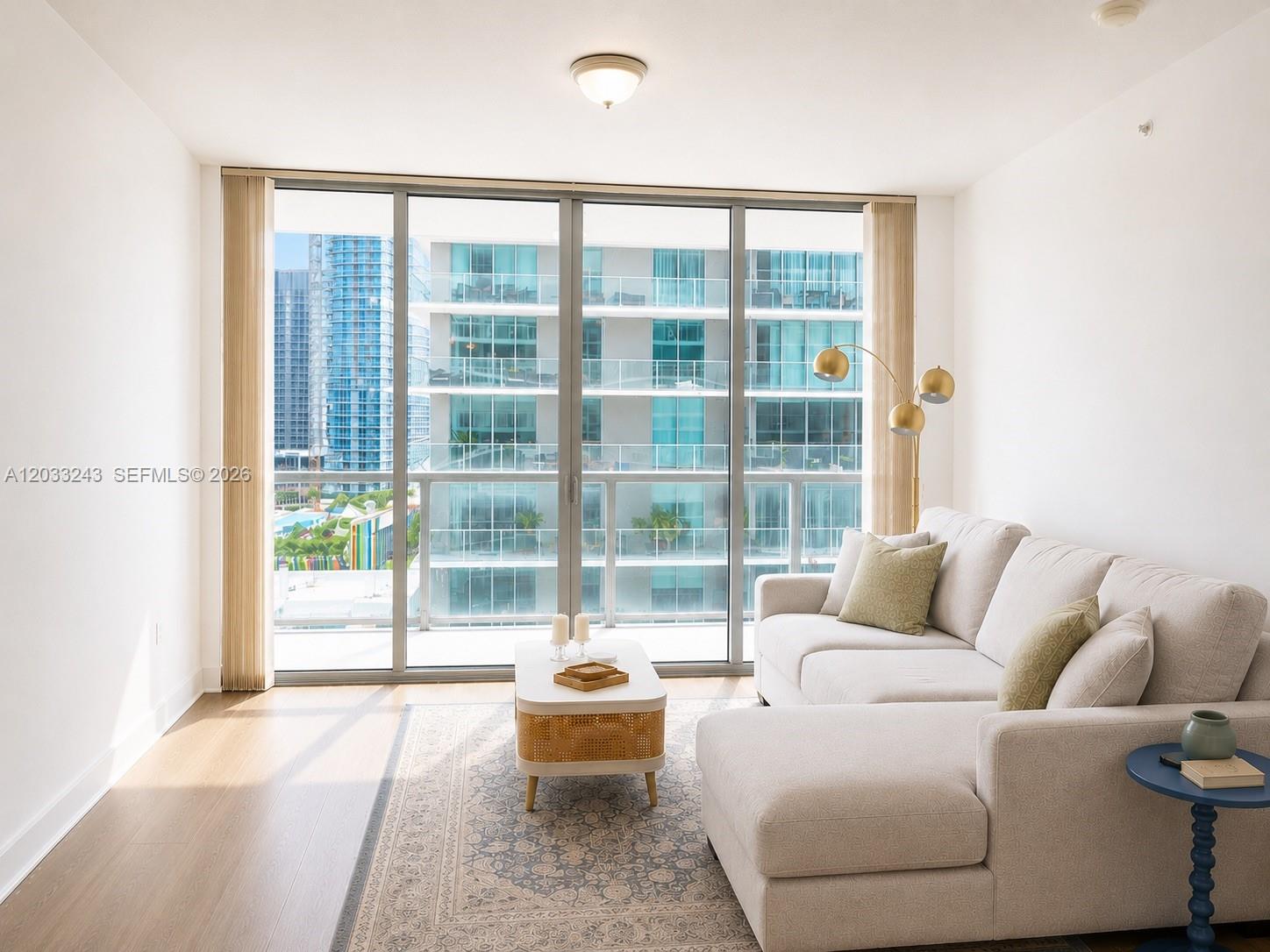 A living room features a sectional sofa, a coffee table, and floor-to-ceiling windows — MIAMI, FL