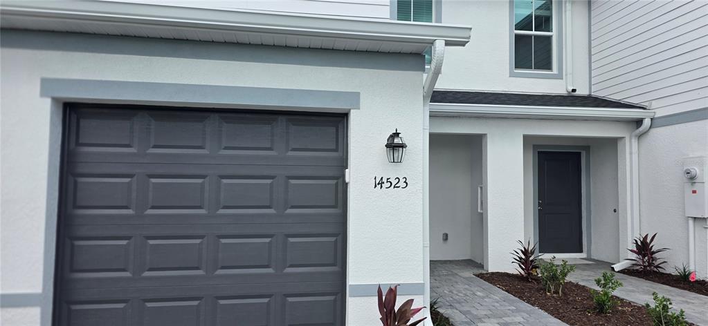 A white two-story townhouse exterior features a dark gray garage door and front door — 14523 LILAC SKY TERRACE, BRADENTON, FL