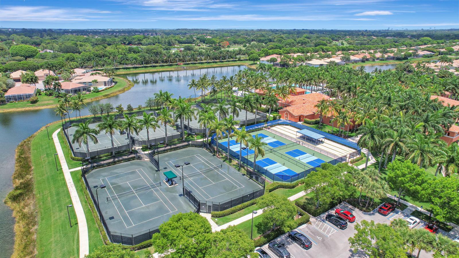 An aerial view of a suburban neighborhood with houses, a canal, and a red arrow — 9842 Via Elegante, Wellington FL 33411, WELLINGTON, FL