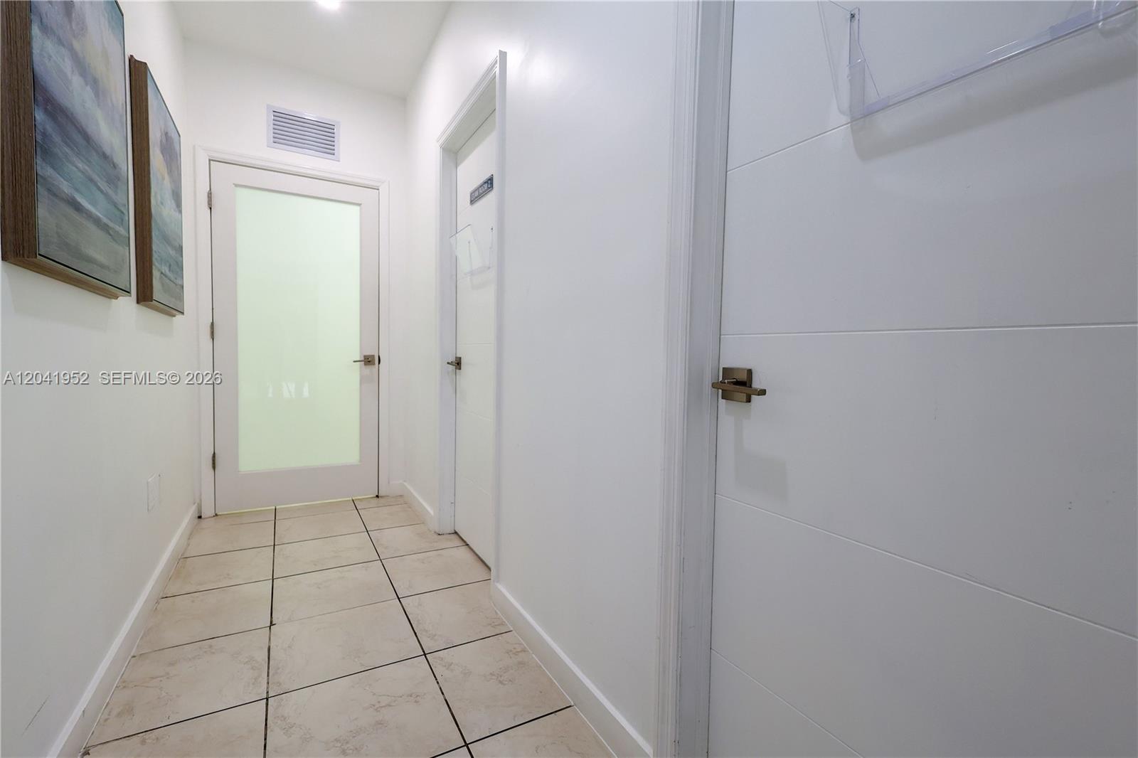 A hallway with white walls, tiled floors, and three closed doors — 8525 SW 92nd St # 11B, Miami FL 33156, MIAMI, FL