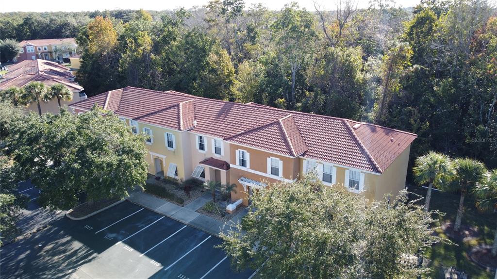 An aerial view of a multi-unit residential building with a red tile roof and parking — 1115 PARK RIDGE CIRCLE, KISSIMMEE, FL