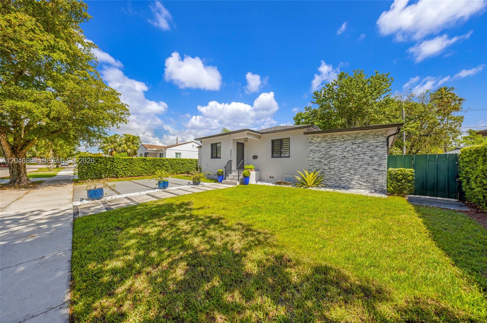 A single-story house with a stone-accented facade, a green lawn, and a paved walkway — 6541 SW 18th St, West Miami FL 33155, WEST MIAMI, FL