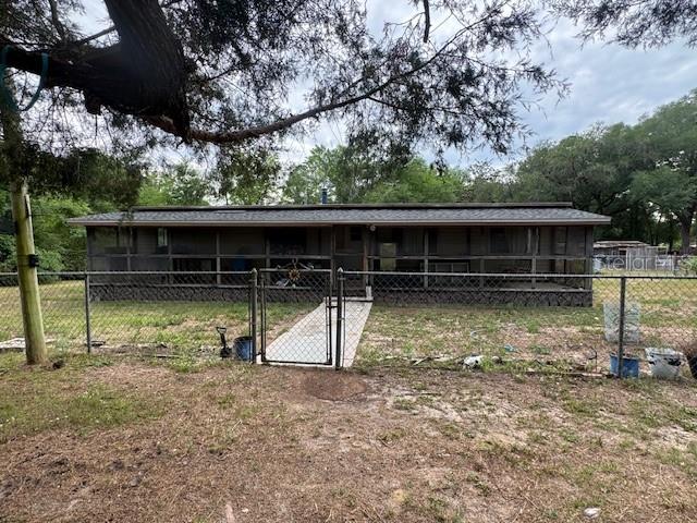 A single-story house with a screened-in porch sits behind a chain-link fence — 2462 HARVEY MILL CREEK ROAD, TALLAHASSEE, FL