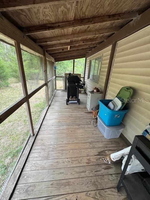 A covered wooden porch features screened walls, a grill, and storage bins — 2462 HARVEY MILL CREEK ROAD, TALLAHASSEE, FL