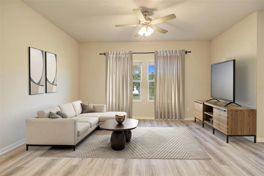A living room features a beige sectional sofa, a wooden coffee table, and a television console — 10 FRENEAU LANE, PALM COAST, FL